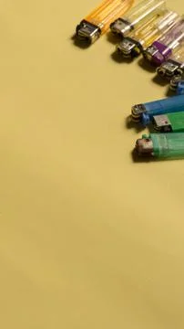 Top view of gas lighters with different colours on yellow background Stock Photos