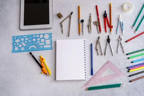 Top view of geometry tools, colorful pencils, and a blank notebook background Stock Photos