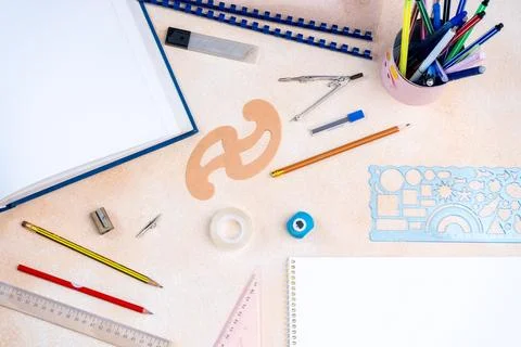 Top view of geometry tools, colorful pencils, and a blank notebook background Stock Photos