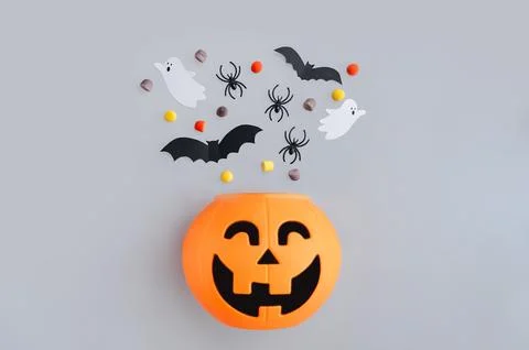 Top view of ghosts, bats, and candies on gray surface, Halloween decoration Stock Photos