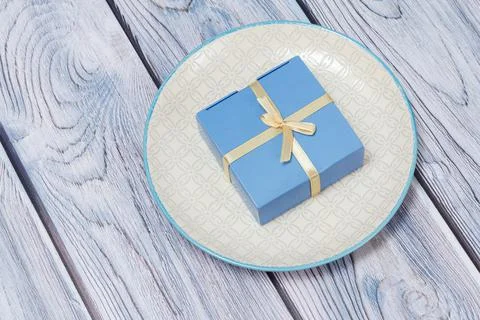 Top view of gift box and plate on wooden background. Stock Photos