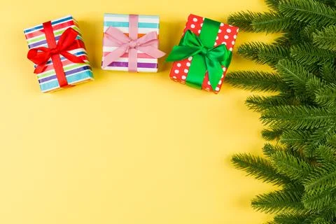 Top view of gift box and fir tree branches on colorful background. Merry Ch.. Stock Photos