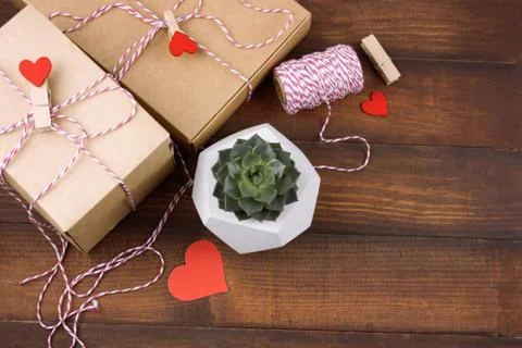 Top view gift boxes with cloth pegs with red hearts and succulent in concrete Foto stock