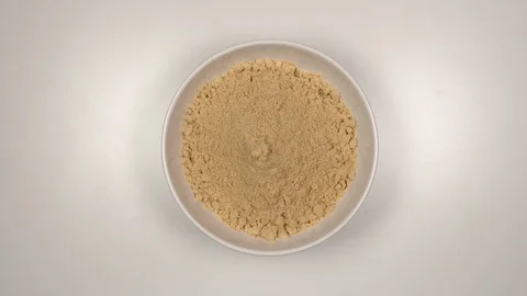 TOP VIEW: Ginger powder fill a white dish - Stop motion Видео 90239817