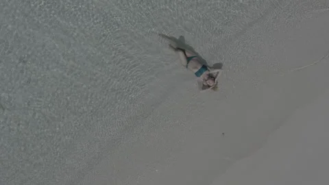 Top view of a girl lying on the beach and being washed by the waves of the sea. Stock Footage 242354672