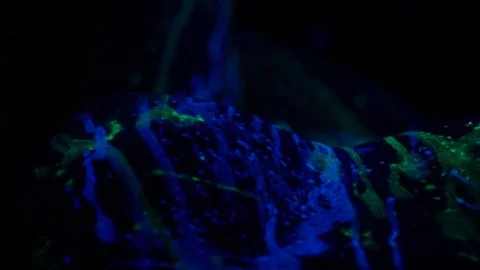 Top view of the girl's tits that lies on the floor with a luminous paint Stock Footage