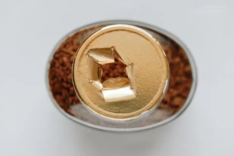 Top view of a glass jar of coffee without a lid, the gold-colored label is torn Stock Photos