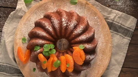 Top View of a Glazed Bundt Cake with Orange Slices and Mint Stock Footage 327763753