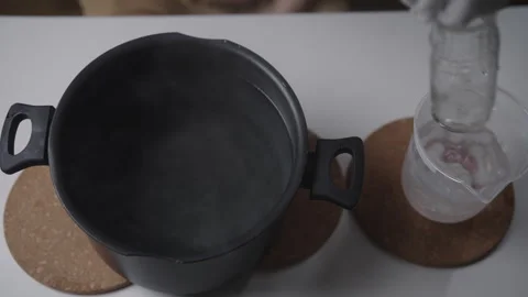 Top view of gloved hands creating thermal shock by alternating hot glass bottle Stock Footage 342766100