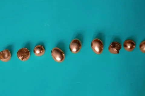 Top view golden easter eggs and egg shells on a blue background Stock Photos