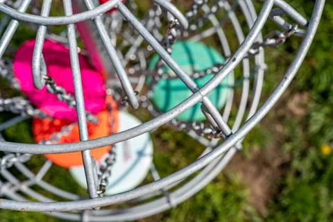 Top view of a golf basket chains with discs blurred below Stock Photos
