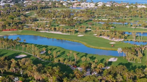 Top view of golf course with large water hazard surrounded by lush greenery and Stock Footage 275905738