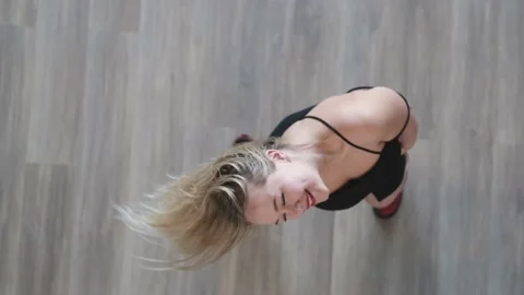 Top view of a gorgeous cheerful blonde woman in a black dress dancing joyfully Stock Footage 226537982