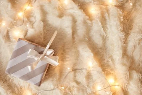 Top view of gray wrapped present box on white soft blanket decorated with gar Stock Photos