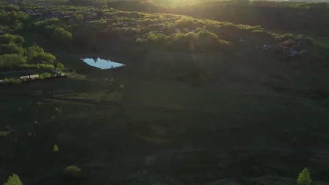 Top view of green fields and forests. A bird flies over a lake in the forest.  Stock Footage 274206133