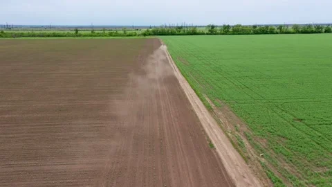 Top view of a green meadow with grass, car movement on a dirt road a lot of dust Stock Footage 130537761