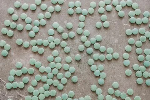 Top view of green spirulina chlorella supplement pills scattered on dark gr.. Stock Photos