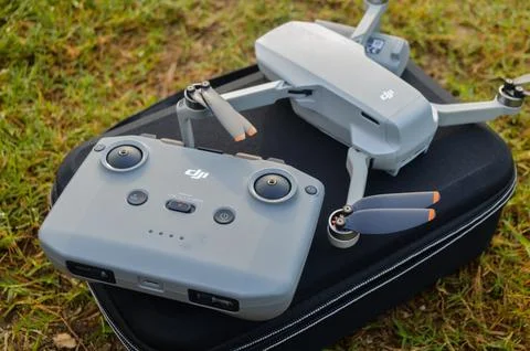 Top view of the grey DJI Mini 2 drone and remote above the bag and in nature Stock Photos