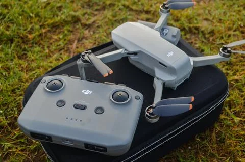 Top view of the grey DJI Mini 2 drone and remote above the bag and in nature Stock Photos