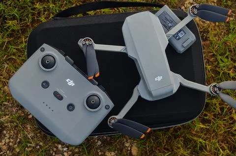 Top view of the grey DJI Mini 2 drone and remote above the bag and in nature Stock Photos