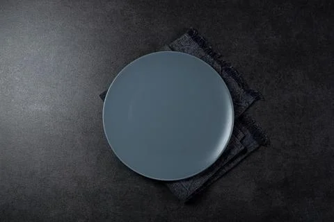 Top view of grey empty plate on dark grey background Stock Photos