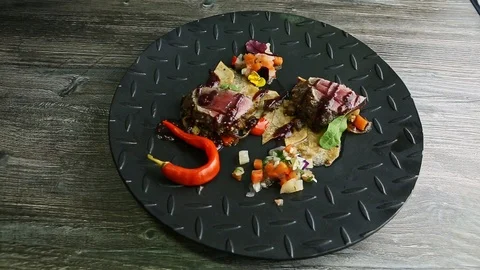 Top view at grilled meat pieces with potato chips and vegetable salad on black Stock Footage 122112367