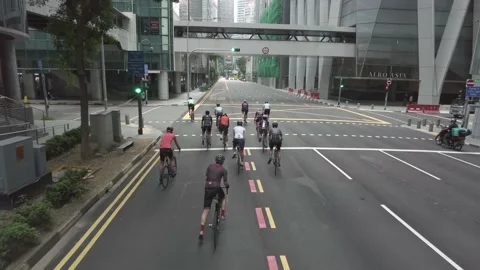 Top view of group of cyclists cycling on empty road in the city Stock Footage 165179446