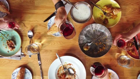 Top View of a group of friends having a meal toasting with wine At Wooden Table. Stock Footage