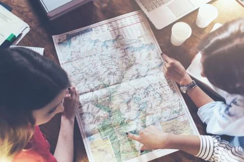 Top view of group of girls with map sitting at desk 写真素材