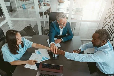 Top view of group multi ethnic coworkers stacked hands together as concept of Stock Photos