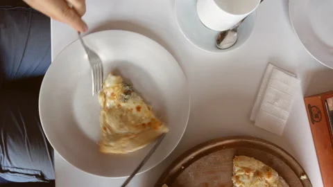 Top view. guy with a knife and fork cuts off a slice of pizza. homemade feast. Stock Footage 111398476