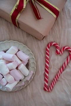 Top View of Half Mug with Marshmallows and Half Gift Box with Heart Candy Foto stock