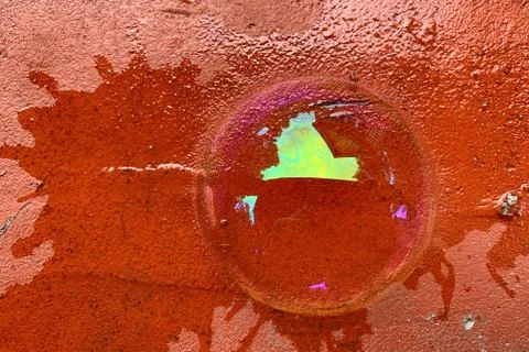 The top view of a half soap bubble lies on a cracked red brick Stock Photos