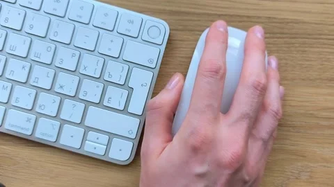 Top view of a hand clicking and scrolling a mouse. Keyboard visible nearby .. Stock Footage 340284092