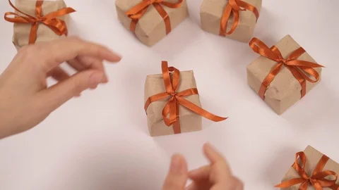 Top view of a hand opening a tiny nicely decorated with a ribbon gift box. A Stock Footage 119759757