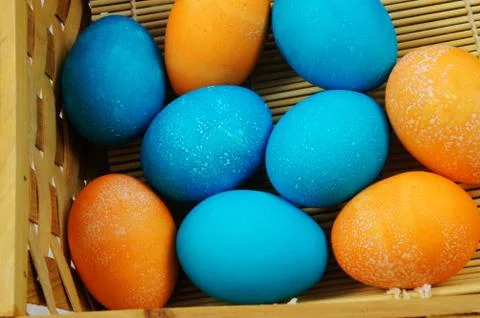 Top view of hand-painted Easter eggs in white, orange, blue and pink colors. Stock Photos
