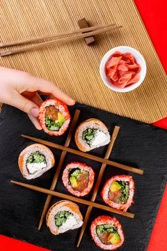 Top view of hand picking sushi from slate board Stock-Fotos