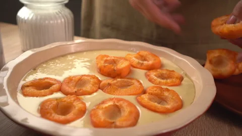 Top view of hand placing fresh apricot on homemade berry pie. Concept of ba.. Stock Footage 341335936