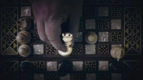 Top view of a hand playing chess game on old peeled of colored wooden table Stock Photos