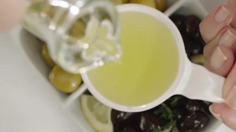Top View Hand Pouring Olive Oil Over Green and Black Olives with Lemon 4K Vídeos de archivo 344927957