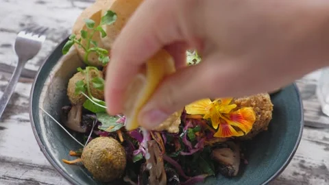 Top view of hand squeezing lemon on healthy delicious vegan Buddha bowl Stock Footage 147231905