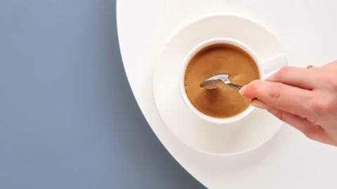 Top view of hand stirring coffee with spoon. Making morning coffee with milk Stock Footage 141510985