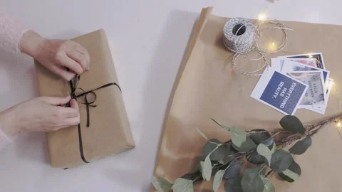 Top View of Hand Tying a Ribbon on Top of a Christmas Gift Stock Footage 144985127