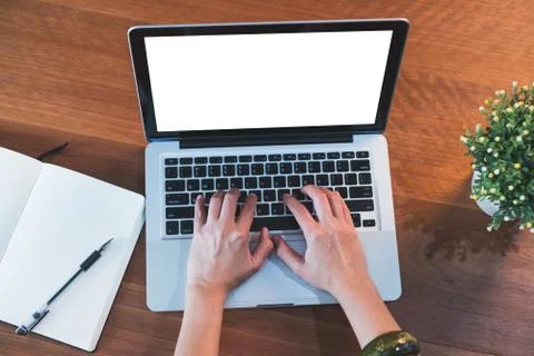 Top view hand type on laptop keyboard with open notebook and plant on table a Stock Photos