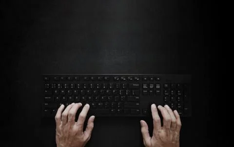 Top view, Hand typing computer keyboard on black background Stock Photos
