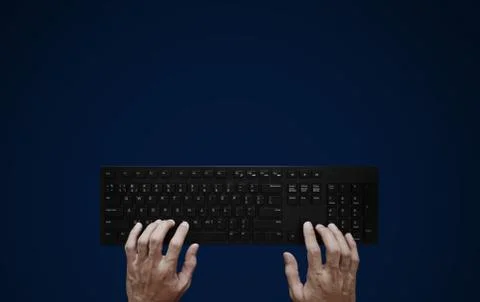 Top view, Hand typing computer keyboard on blue background Stock Photos