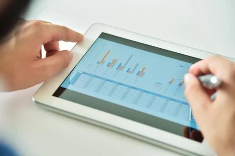 Top view of hand using digital tablet computer  with financial data. Stock Photos