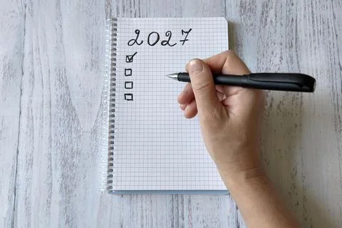 A top view of a hand writing a to-do list in a 2027 notebook Stock Photos