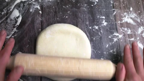 Top view of hands and a rolling pin, making pizza or bread dough, rolling dough Stock Footage 243091265