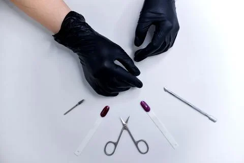 Top view of hands in black gloves, manicure scissors, manicure tools, nail ge Stock Photos